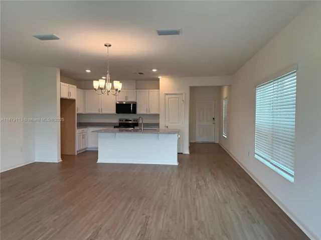 a view of kitchen with sink and refrigerator