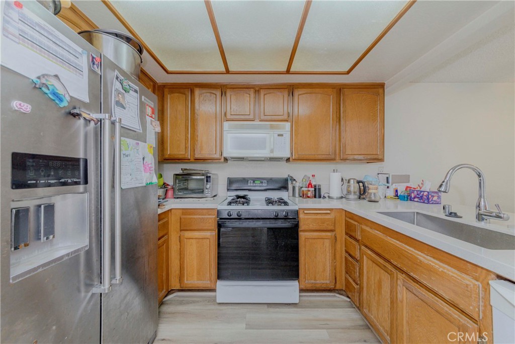 22224 South Vermont Avenue, Unit 102C Torrance, CA 90502 - Photo 12 of 27 a kitchen with stainless steel appliances granite countertop a stove a sink dishwasher and a refrigerator