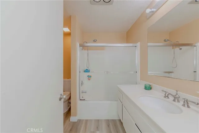 a bathroom with a tub sink vanity and mirror
