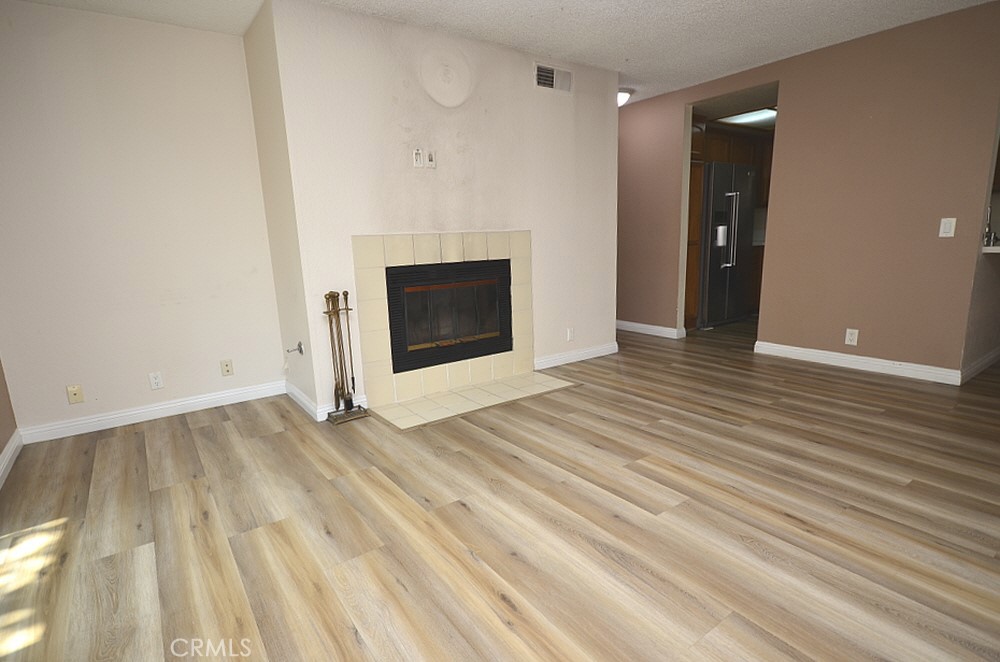 22224 South Vermont Avenue, Unit 102C Torrance, CA 90502 - Photo 10 of 27 a view of empty room with wooden floor and fireplace