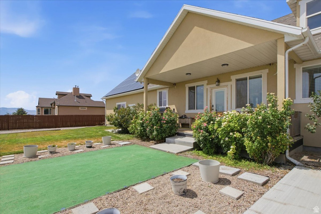 1232 Canyon Road Tooele, UT 84074 - Photo 49 of 54 Rear exterior with covered patio, stucco finish, and solar panels