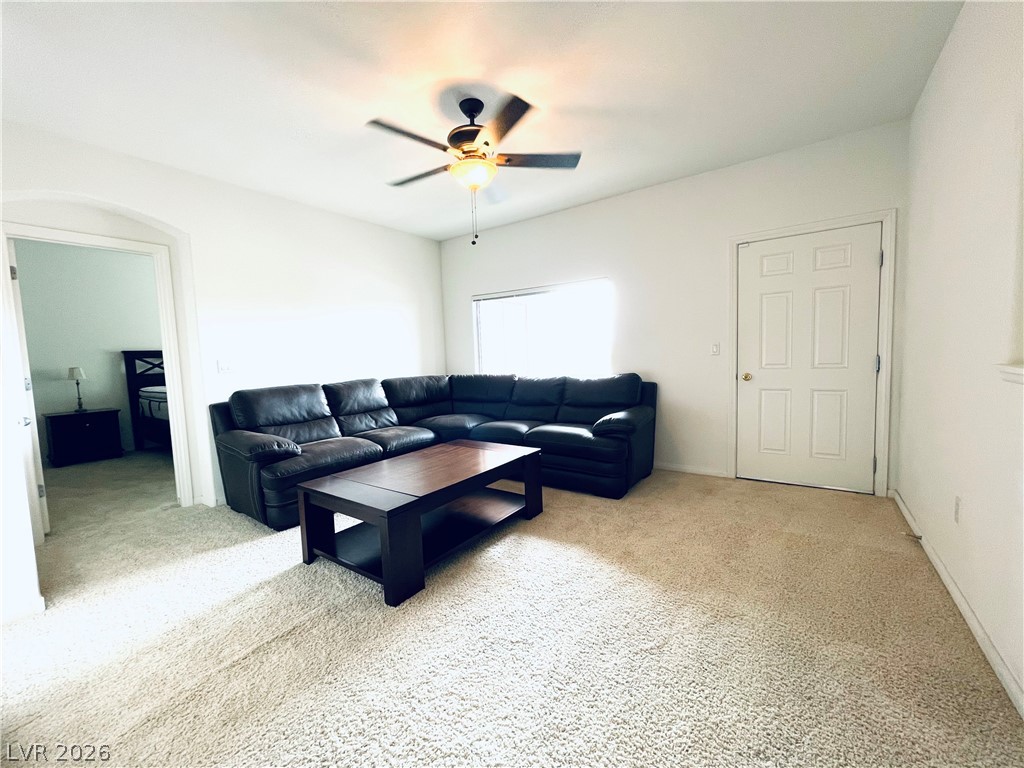 7701 West Robindale Road, Unit 206 Las Vegas, NV 89113 - Photo 4 of 30 Soft carpeting pairs with an open doorway leading to adjacent living spaces.
