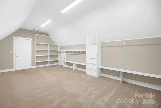 an empty room with a cabinet and mirrors