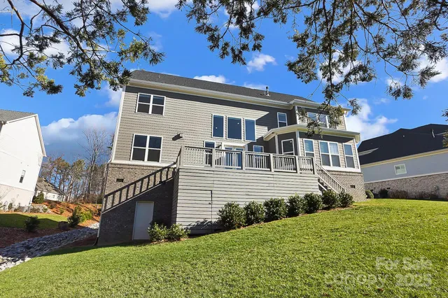 a front view of a house with a yard and trees