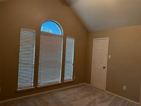 an empty room with windows and cabinet