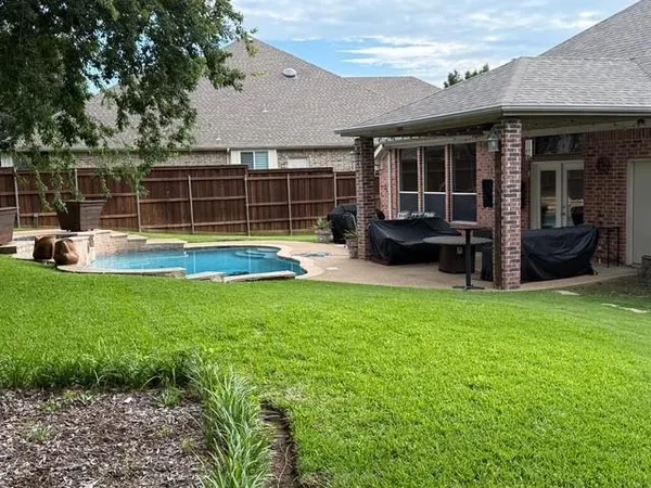 a view of a house with a backyard and a patio