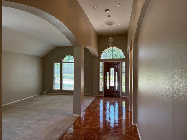 a view of a hallway with wooden floor staircase and a livingroom