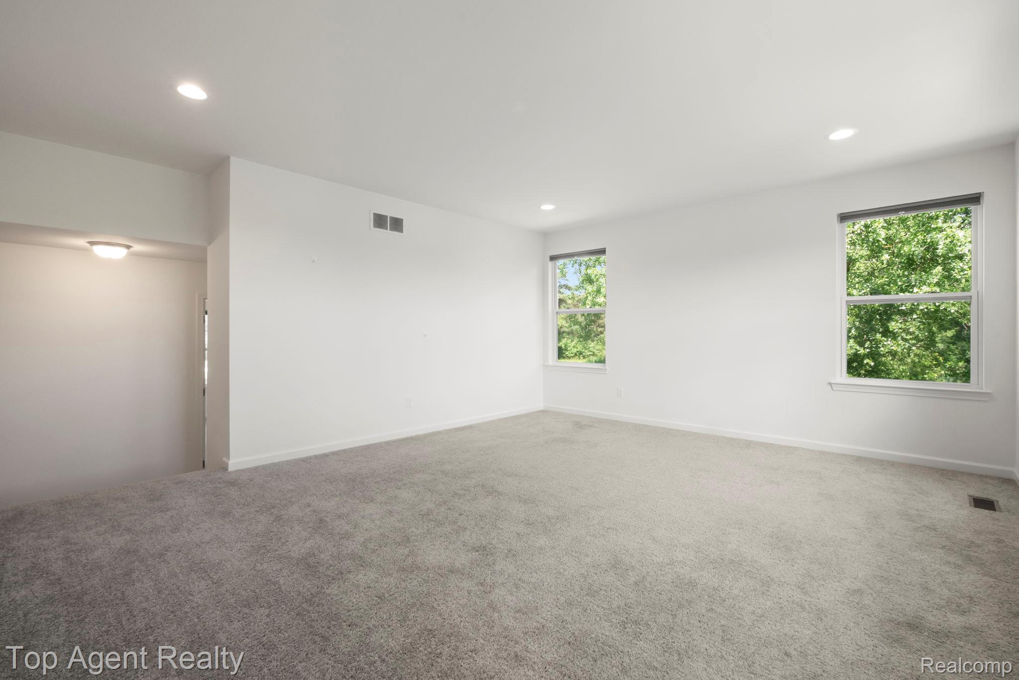 63770 Dequindre Road Washington, MI 48095 - Photo 28 of 61 Spacious room featuring light gray carpeting, crisp white walls, recessed ceiling lighting, and two large windows