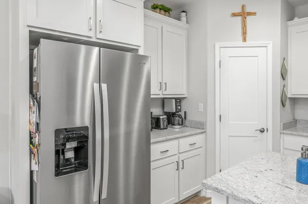 a kitchen with stainless steel appliances kitchen island granite countertop a table chairs refrigerator and sink