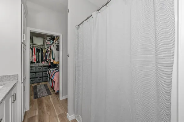 a view of walk in closet with clothes and shoes