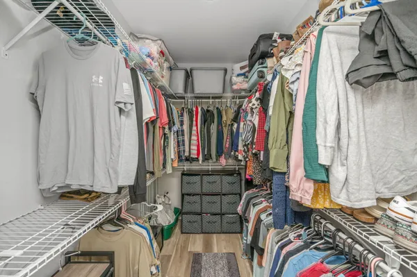 a bedroom with furniture and a chandelier fan