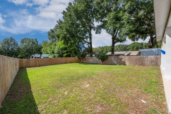 a view of yard with swimming pool and wooden fence