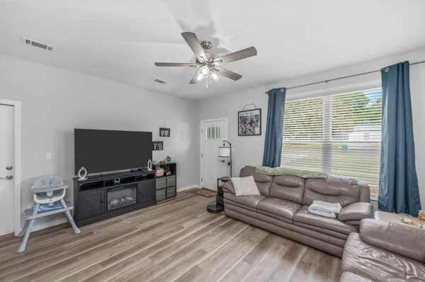 a living room with stainless steel appliances furniture and a flat screen tv