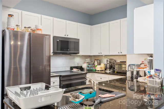 a kitchen with stainless steel appliances a stove a sink and a refrigerator