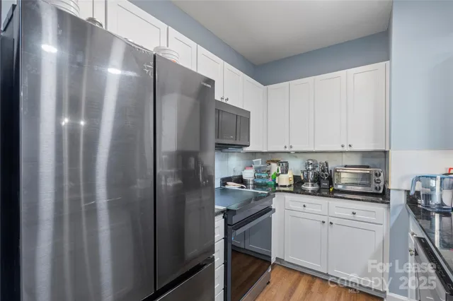 a kitchen with a refrigerator sink and cabinets