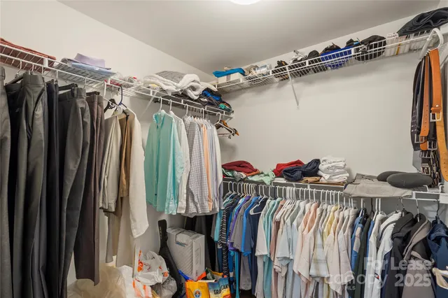a view of walk in closet with clothes and shoes