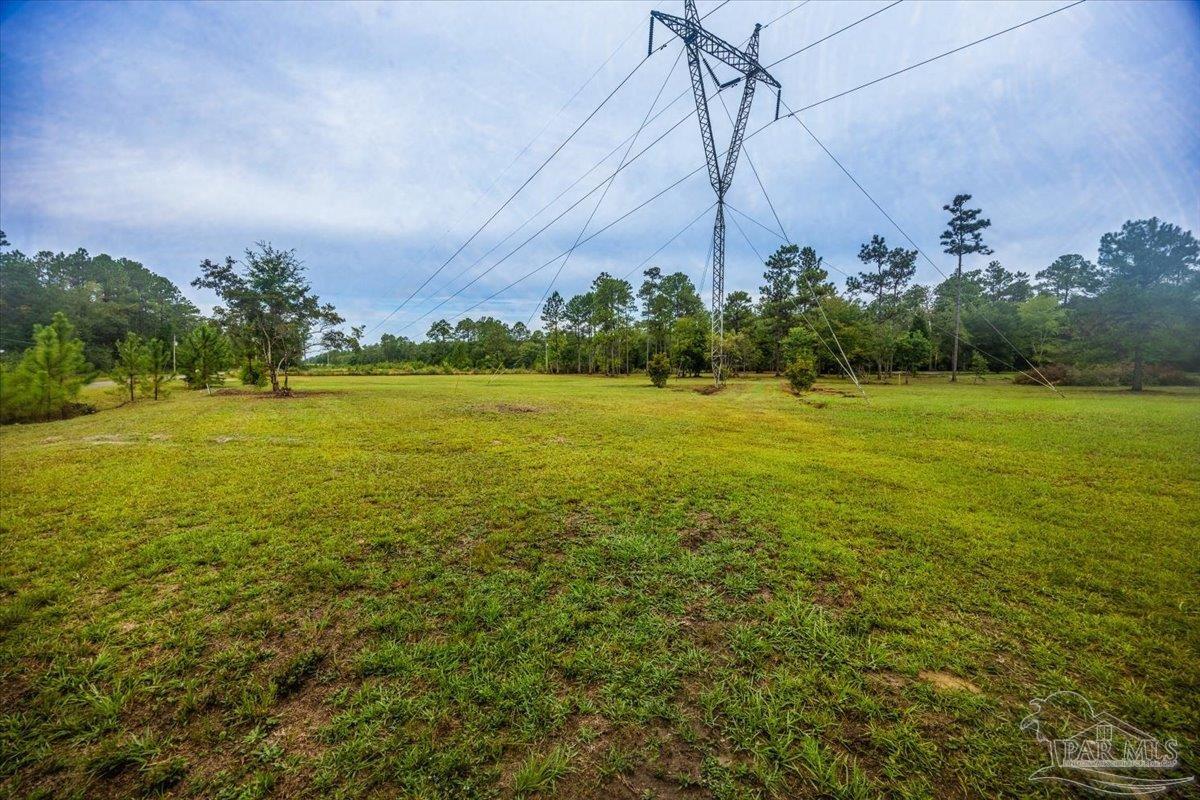 8330 Edith Avenue Milton, FL 32570 - Photo 18 of 19 a view of a field with an ocean and trees in the background