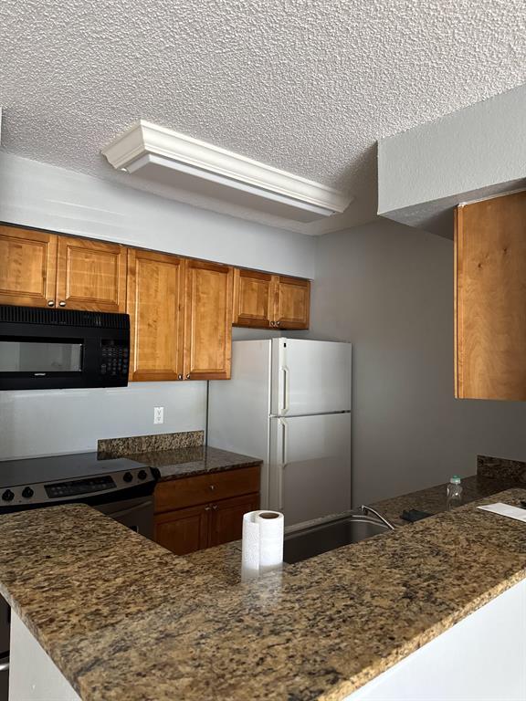 2866 South University Drive, Unit 5101 Davie, FL 33328 - Photo 2 of 6 a kitchen with a stove and a refrigerator