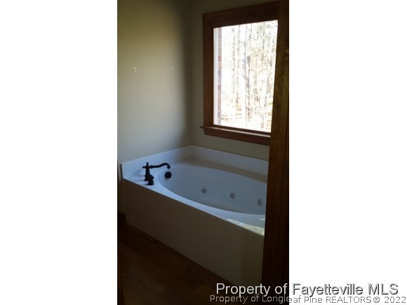 2341 Zacks Mill Road Angier, NC 27501 - Photo 13 of 25 a bathroom with a bathtub and a window