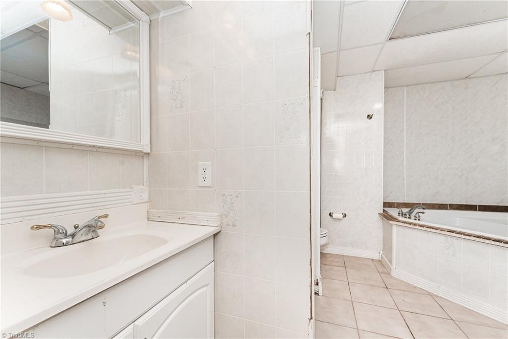 7113 North River Road Oak Ridge, NC 27310 - Photo 21 of 28 Full bathroom in basement with shower and garden tub