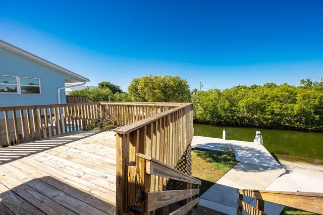 a view of a balcony with wooden floor and lake view