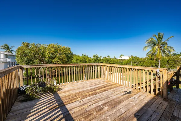 a view of balcony with wooden floor and fence