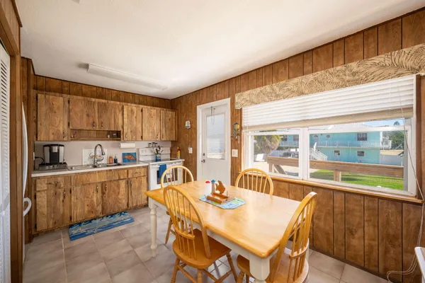 a kitchen with stainless steel appliances kitchen island granite countertop a table chairs sink and cabinets