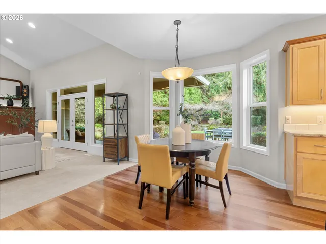 a dining room with furniture wooden floor a chandelier and a rug