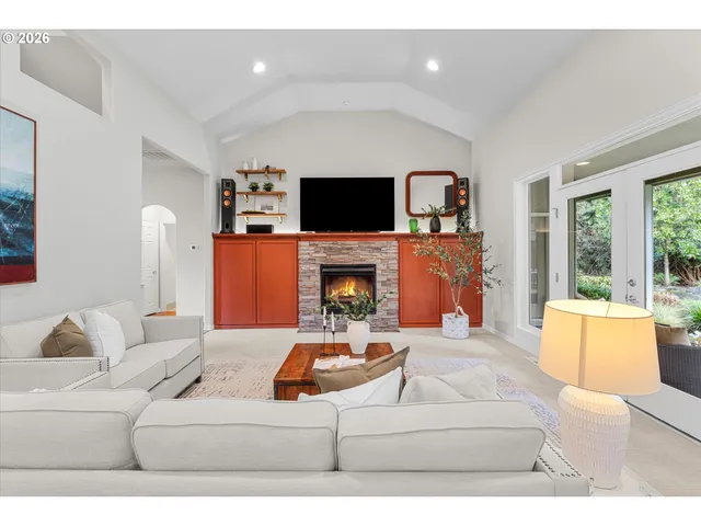 a living room with furniture a flat screen tv and a fireplace