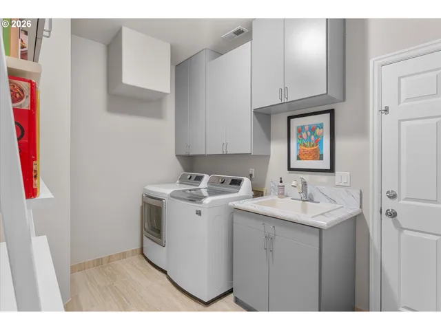 a utility room with sink dryer and washer