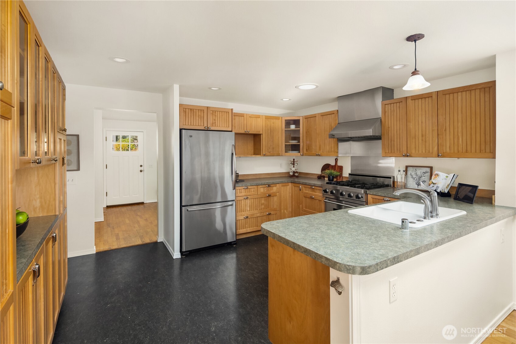 5230 242nd Street Southwest Mountlake Terrace, WA 98043 - Photo 17 of 39 a kitchen with granite countertop a refrigerator a sink a stove a microwave and island