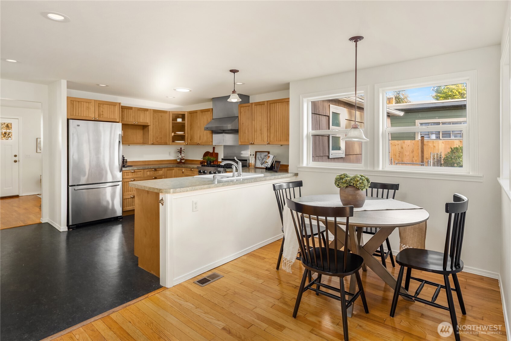 5230 242nd Street Southwest Mountlake Terrace, WA 98043 - Photo 20 of 39 a kitchen with stainless steel appliances a dining table chairs a refrigerator and cabinets