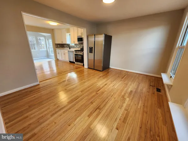 a view of a kitchen with wooden floor and a refrigerator