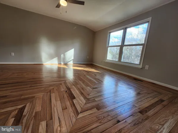 wooden floor in an empty room with a window