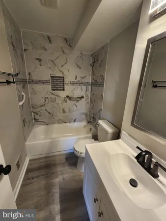a white toilet sitting next to a bathroom sink and a mirror