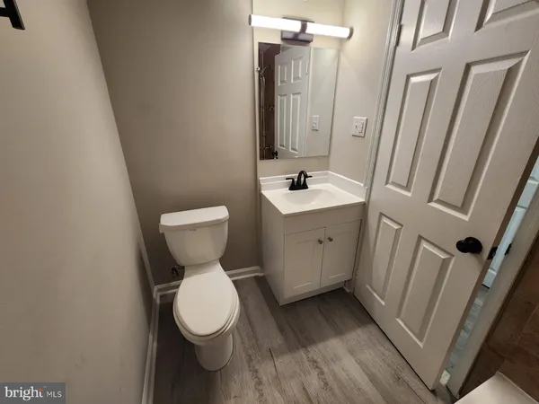a white toilet sitting next to a white sink and vanity