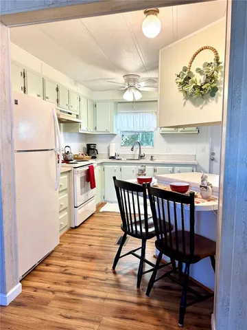a kitchen with stainless steel appliances a white table and chairs in it