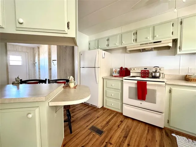 a kitchen with stainless steel appliances granite countertop a sink dishwasher and cabinets with wooden floor