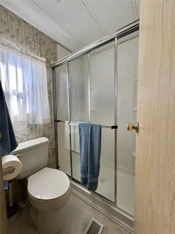 a bathroom with a toilet and a shower