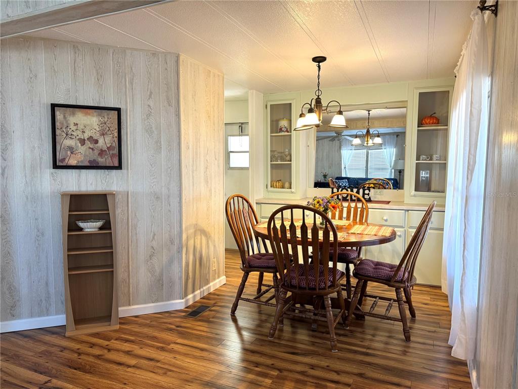 340 Peace Manor Palmetto, FL 34221 - Photo 10 of 38 a dining room with furniture a chandelier and wooden floor