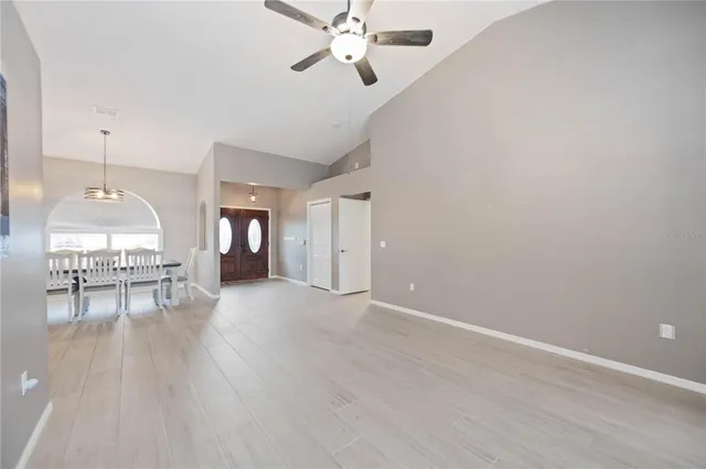 a view of an empty room with window and wooden floor