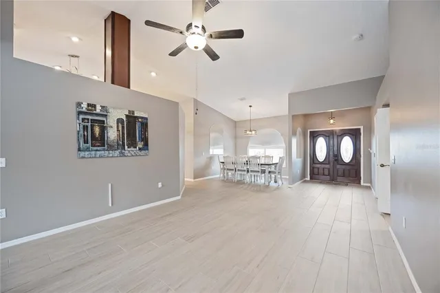 a view of empty room with wooden floor and ceiling fan