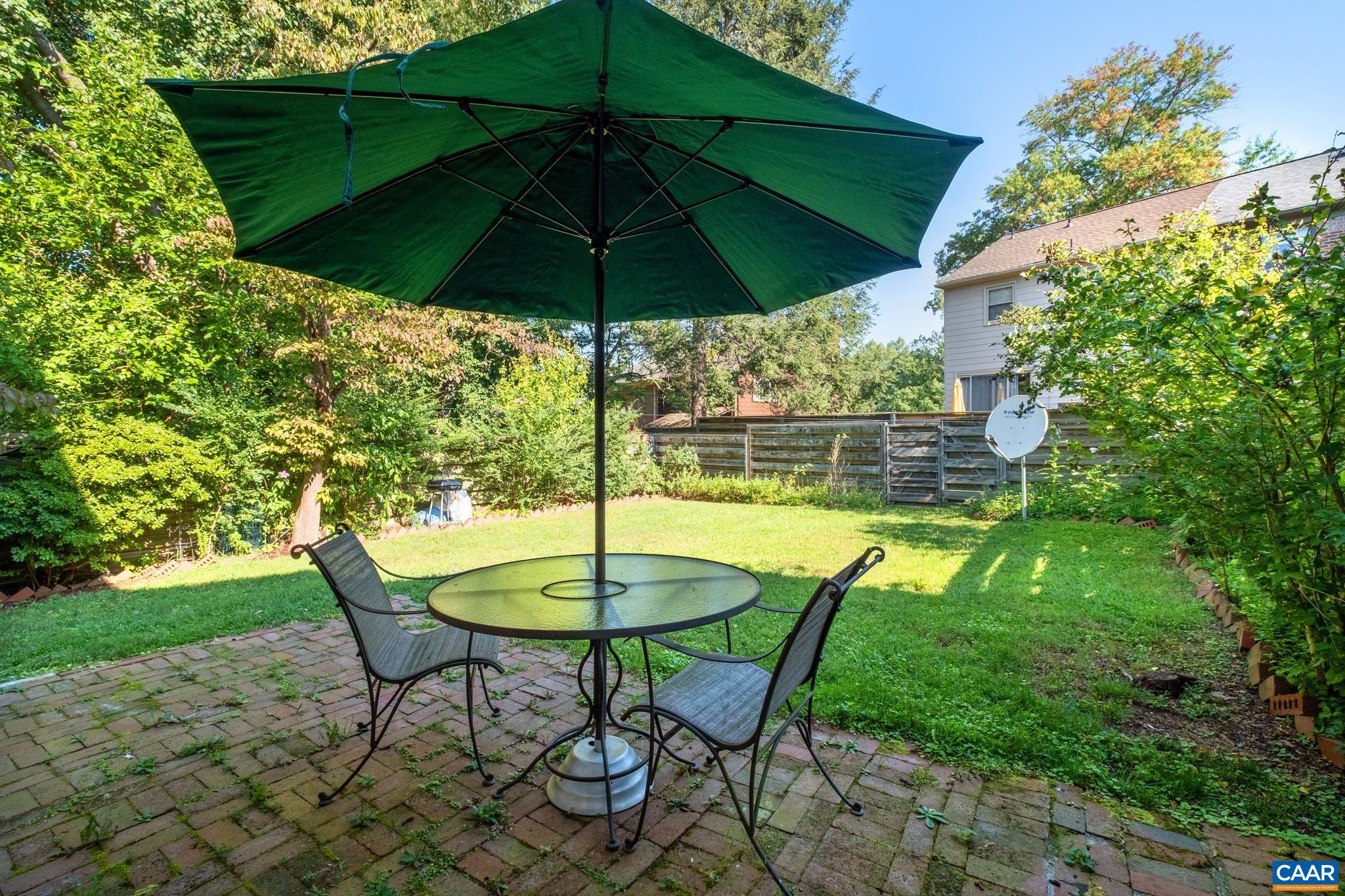 114 Georgetown Green Charlottesville, VA 22901 - Photo 19 of 44 a backyard of a house with table and chairs under an umbrella