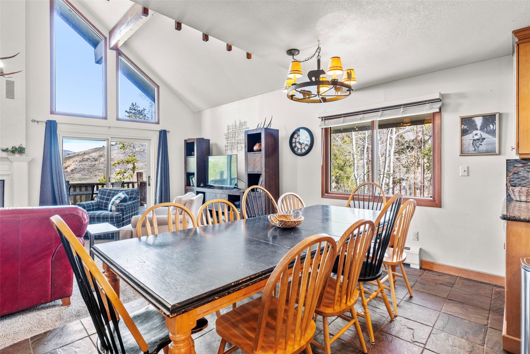 79 Forest Canyon Road Dillon, CO 80435 - Photo 14 of 50 Tiled dining space featuring vaulted ceiling with beams, a textured ceiling, a baseboard heating unit, and an inviting chandelier