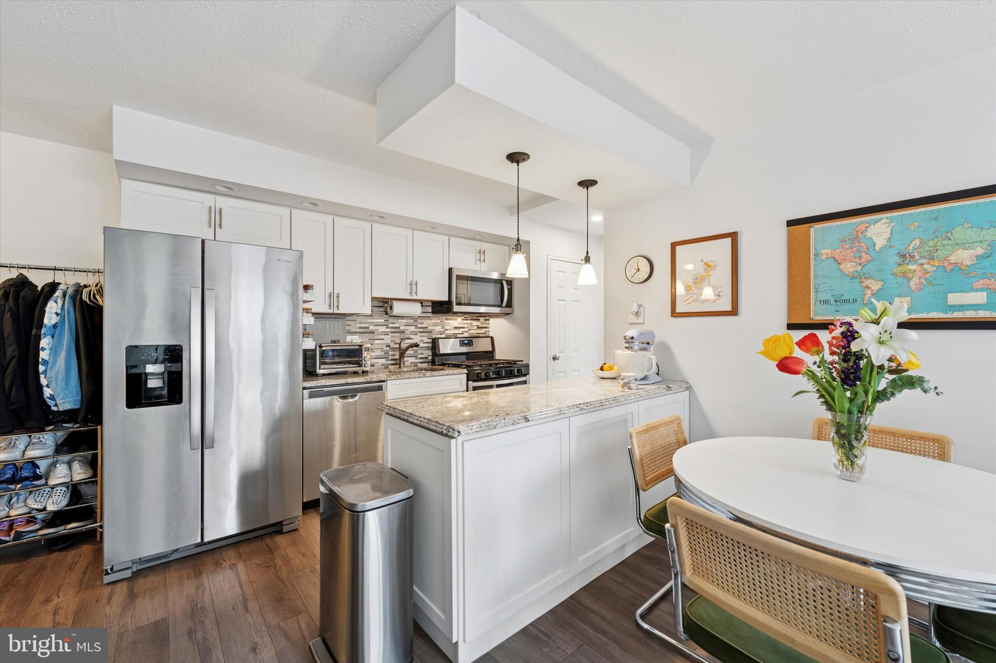 a kitchen with a refrigerator a stove a sink dishwasher and white cabinets with wooden floor