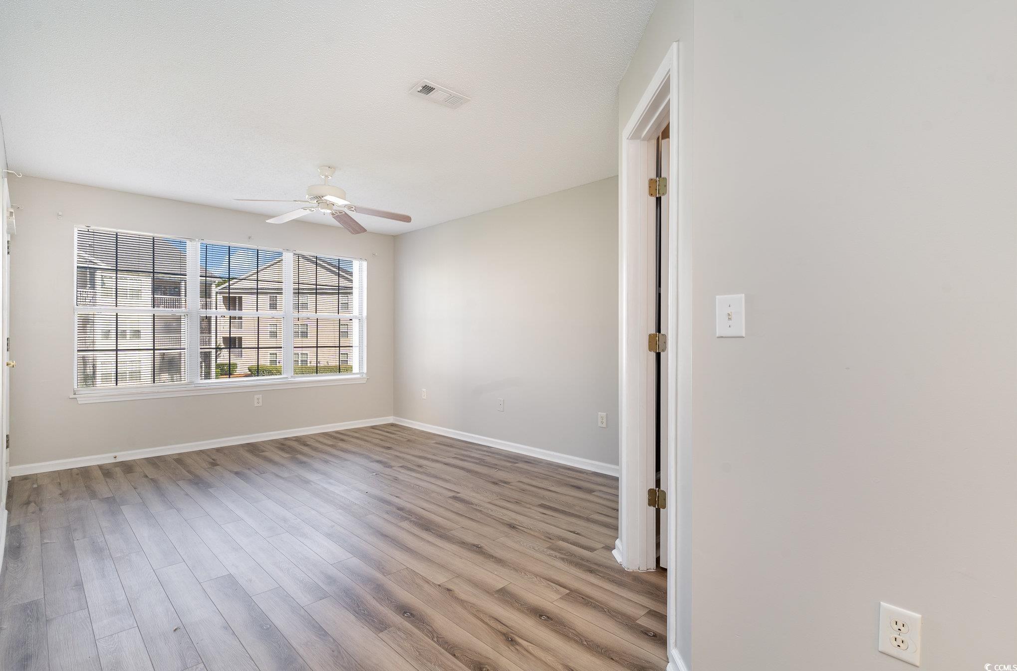 651 Woodmoor Drive, Unit 201 Murrells Inlet, SC 29576 - Photo 15 of 35 Unfurnished room featuring light wood-type flooring and a ceiling fan