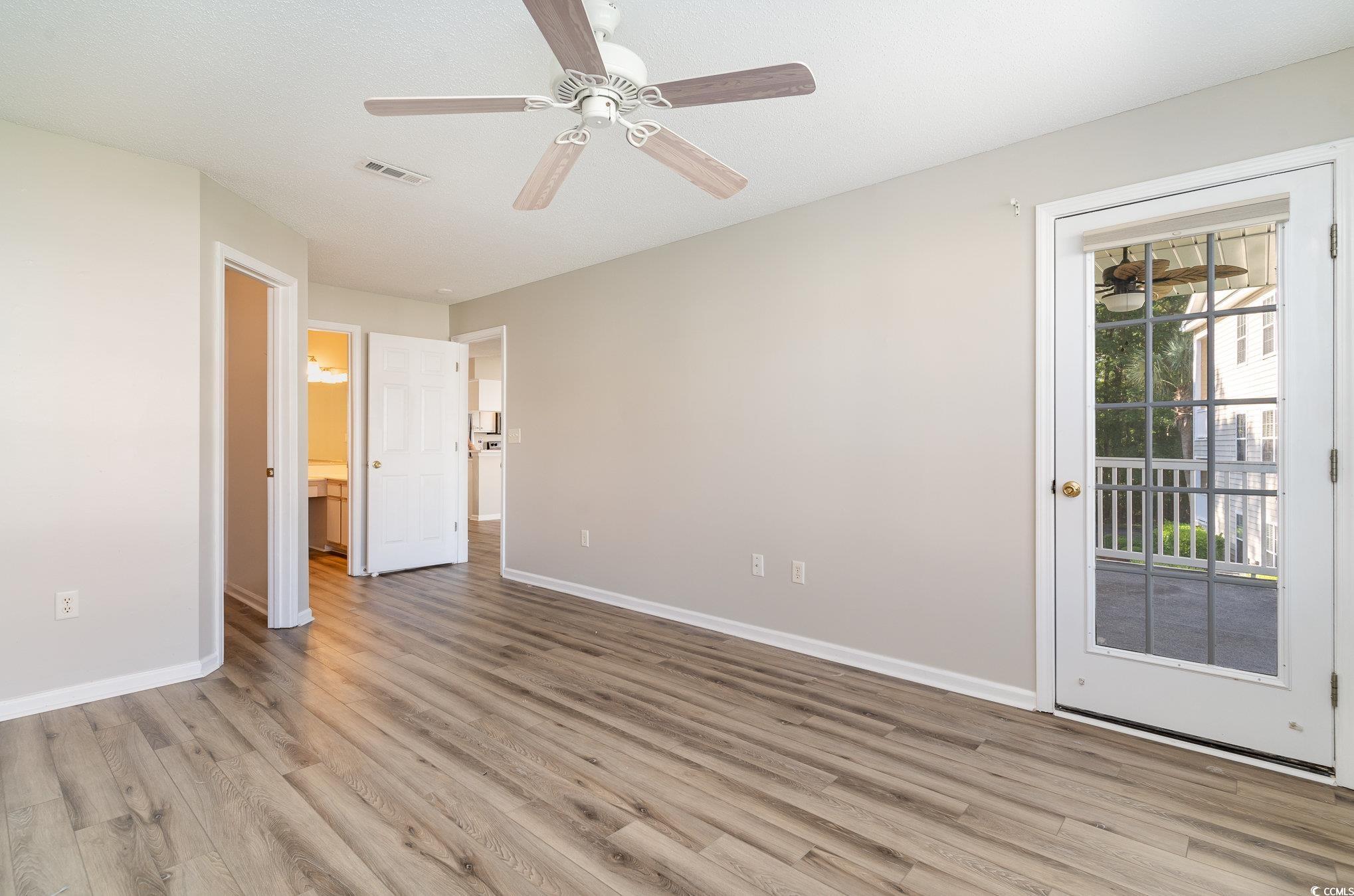 651 Woodmoor Drive, Unit 201 Murrells Inlet, SC 29576 - Photo 16 of 35 Unfurnished bedroom featuring access to exterior, light wood-type flooring, and a ceiling fan