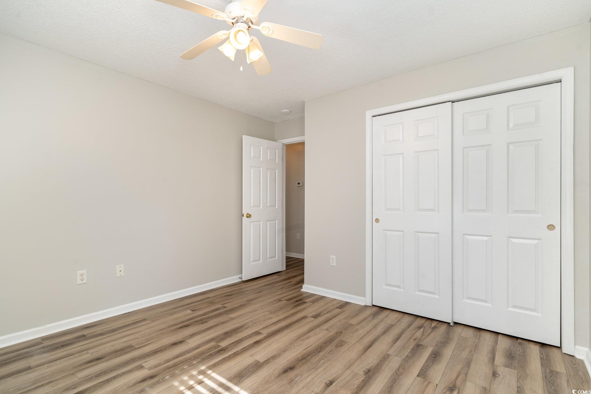 651 Woodmoor Drive, Unit 201 Murrells Inlet, SC 29576 - Photo 21 of 35 Unfurnished bedroom with light wood-style floors, a closet, and ceiling fan