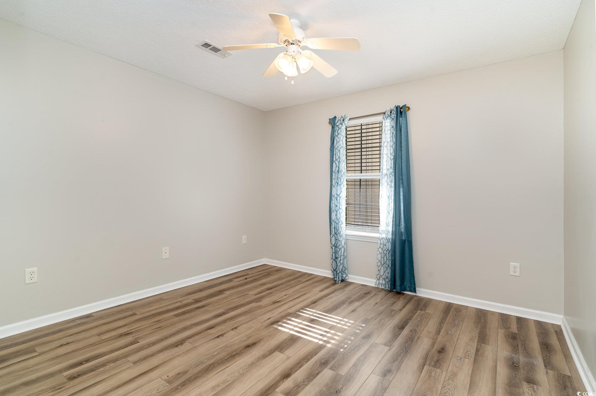651 Woodmoor Drive, Unit 201 Murrells Inlet, SC 29576 - Photo 22 of 35 Spare room with wood finished floors and ceiling fan
