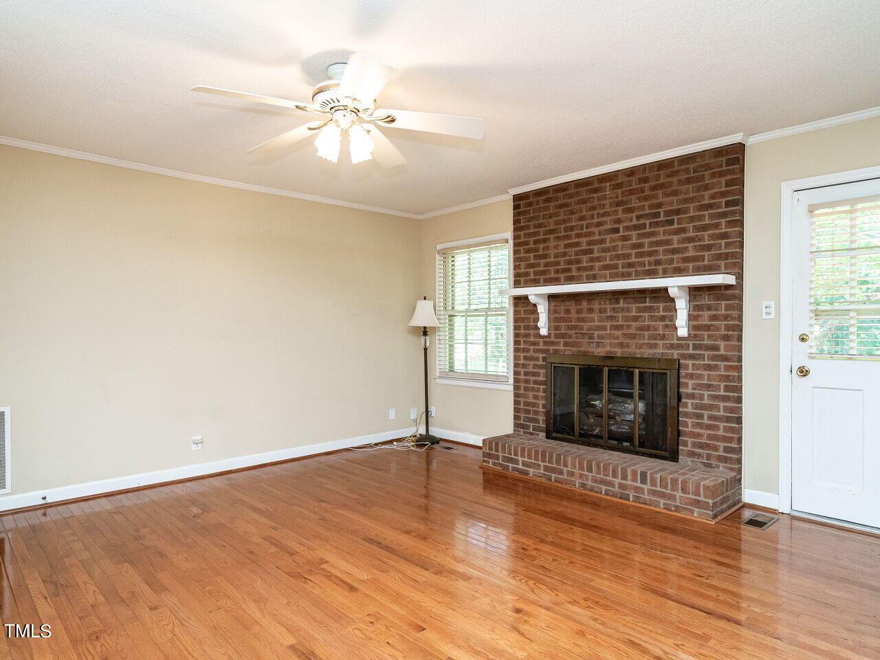 6600 Barbee Road Durham, NC 27713 - Photo 16 of 33 an empty room with wooden floor fireplace and windows